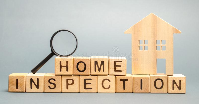 Wooden home and magnifying glass with block letters saying home inspection. 