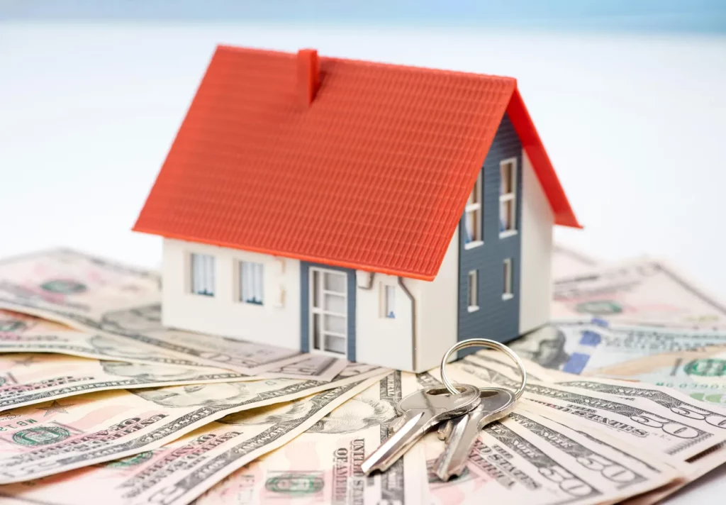 house sitting on money with keys