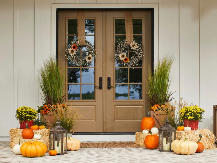A charming front porch decorated with pumpkins and fall foliage, ideal for curb appeal tips.